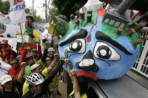 Activists shout slogans beside an effigy of Mother Earth outside the Department of Environment and Natural Resources headquarters in suburban Quezon City, north of Manila, Philippines