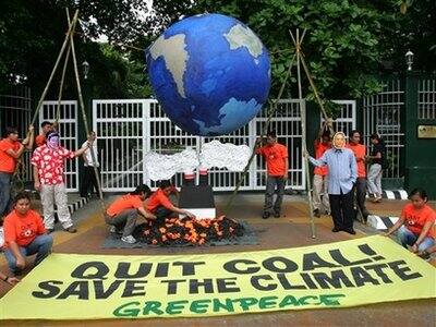 Greenpeace activists unfurl a streamer and display a replica of Planet Earth during a rally commemorating Earth Day in front of the Department of Environment and Natural Resources in suburban Quezon City, north of Manila, Philippines.