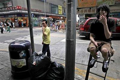 Smokers gather around an ashtray built in on top of a rubbish bin on Earth Day. Earth Day is celebrated worldwide every April 22, marking the anniversary of the birth of the modern environmental movement in 1970.