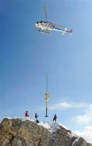 A helicopter transports the summit cross of Germany`s highest mountain, the Zugspitze near Garmisch-Partenkirchen, southern Germany