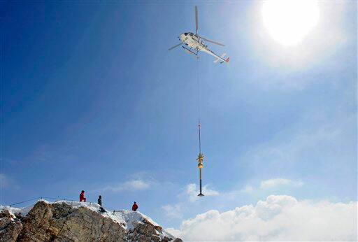 A helicopter transports the summit cross of Germany`s highest mountain, the Zugspitze near Garmisch-Partenkirchen, southern Germany