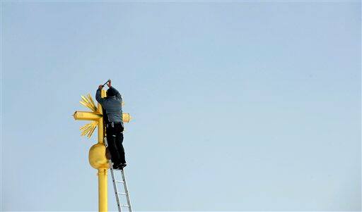 A worker fixes the cover plate of the summit cross of Germany`s highest mountain, the Zugspitze near Garmisch-Partenkirchen, southern Germany.