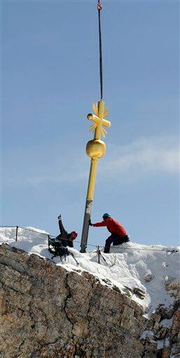 Workers fix the the summit cross of Germany`s highest mountain, the 2,962 meter-high Zugspitze, near Garmisch-Partenkirchen, southern Germany