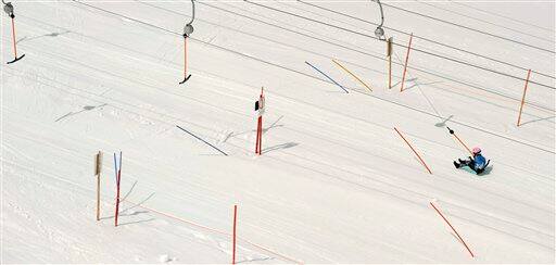 A young boy sits in his sledge in a ski lift on the Zugspitz plateau near the German highest mountain Zugspitze (2,962 meter), southern Germany.