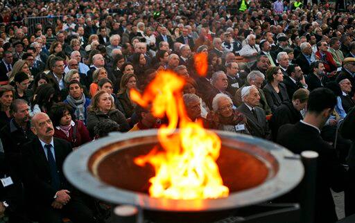 A crowd listens to a speech during a ceremony to mark Israel`s Holocaust day at the Place de la Nation, outside the UN headquarters in Geneva, Switzerland.