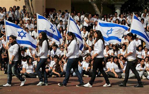 Israeli students, carrying Israeli flags, participate in a ceremony marking Holocaust Remembrance Day, at a high school in the southern Israeli city of Ashkelon.