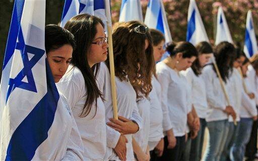 Israeli students, carrying Israeli flags, participate in a ceremony, marking Holocaust Remembrance Day, at a high school in the southern city of Ashkelon