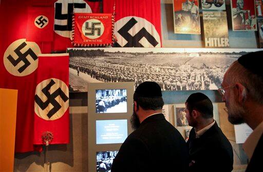 Ultra-Orthodox Jewish men look at a display including Nazi flags and archive footage at the Yad Vashem Holocaust museum in Jerusalem. Frenetic Israel came to a standstill for two mournful minutes on Tuesday as air-raid sirens pierced the air in remembrance of the 6 million Jews who perished in the Nazi Holocaust.