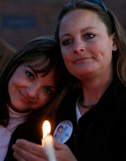 Coni Sanders, left, and Cindy Thirouin, step daughters of teacher Dave Sanders, attend a candlelight vigil at the Columbine High School memorial at Clement Park, near Littleton, Colo., on Sunday, April 19, 2009. Sanders and twelve students were killed at Columbine High School 10 years ago.