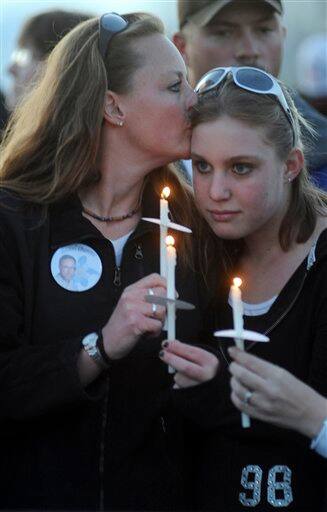 Cindy Thirouin, left, kisses her daughter Tiffany Strole, a freshman at Columbine High School, at a candlelight vigil at the Columbine Memorial at Clement Park near Littleton, Colo., on Sunday, April 19, 2009. Cindy Thirouin is the daughter of Dave Sanders, who was killed in the Columbine attack.