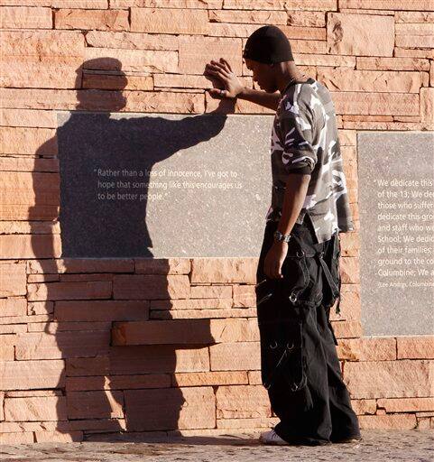 Charles Russell, 25, of Dover, Delaware reads the inscriptions at the Columbine High School Memorial at Clement Park, near Littleton, Colo., on Sunday, April 19, 2009, prior to a candle light vigil. Monday is the 10th anniversary of the shooting at Columbine.