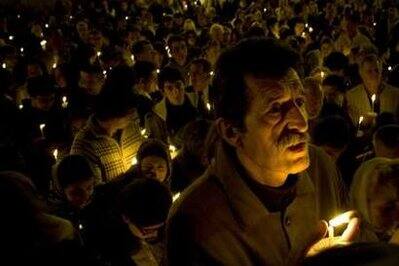 Orthodox Christians hold candles during the Easter Resurrection service at the church of the Nativity of the Lord in Palma de Mallorca April 18, 2009.