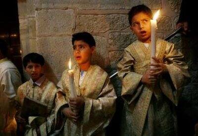 Palestinian Orthodox Christians hold candles during Easter Mass at al-Roum Church in Gaza City early April 19, 2009.