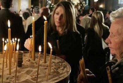 Bosnian Orthodox Christians light candles during the morning Easter service at the Saborna church in Sarajevo April 19, 2009.