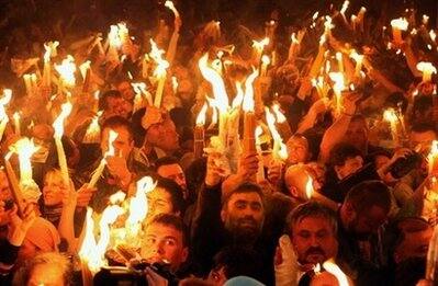 Orthodox Christians hold up candles lit from the `Holy Fire` as thousands gather in the Church of the Holy Sepulchre in Jerusalem on April 18.