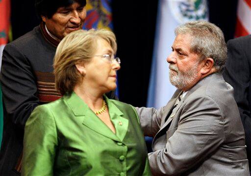 Chile`s President Michelle Bachelet, left, looks as Brazil`s President Luiz Inacio Lula da Silva, right, who greets Bolivia`s President Evo Morales during the opening ceremony of the 5th Summit of the Americas in Port of Spain, Trinidad and Tobago, Friday April 17, 2009.