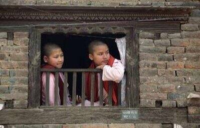 Buddhist nuns watch the second day of celebrations for Navavarsha, or the Nepalese New Year, at Thimi, in Kathmandu April 15, 2009. Navavarsha, which falls on April 14 this year, is a national holiday and people celebrate by carrying chariots of various Gods and Goddesses. This year the Nepalese people usher in the year 2066, in accordance to the Nepali Bikram Sambat calendar.