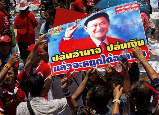 Thai anti-government protesters react as they put water on picture of ousted Prime Minister Thaksin Shinawatra after leaders called off their rally outside the government house in Bangkok, Thailand.