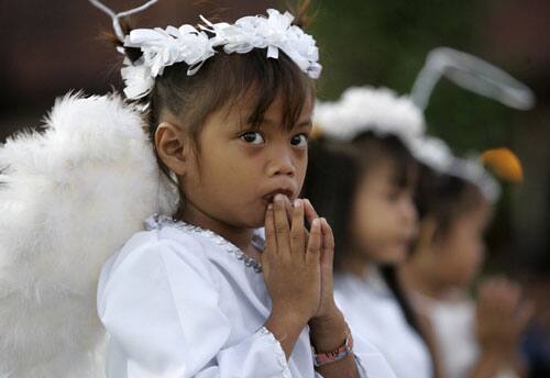 A Filipino girl dressed as an angel joins prayers during Easter rites at a Roman Catholic church in Manila, Philippines early Sunday, April 12, 2009. Aside from prayers, Easter Sunday is celebrated by many Filipinos with family reunion and outings in the Philippines, Asia`s largest predominant Roman Catholic country.