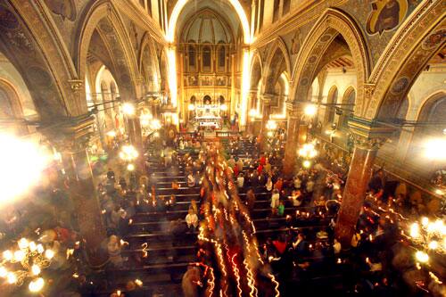 Catholic worshipers walk with lit candles in the St. Iosif cathedral in Bucharest, Romania, Sunday, April 12, 2009, during Catholic Easter celebrations. Romanian Catholics celebrate Easter a week before the country`s Orthodox majority.