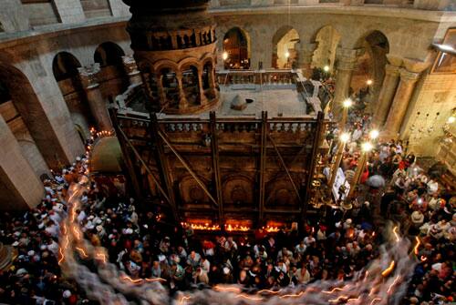 Catholic pilgrims and clergymen hold candles as they walk in procession around the tomb traditionally believed to be the site of the crucifixion and burial of Jesus Christ, during the Easter mass in the Church of the Holy Sepulchre, in Jerusalem`s Old City, Sunday, April 12, 2009.