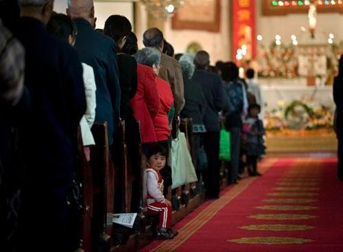 A child looks while Chinese Catholics participate in an Easter mass at the Nantang church in Beijing, China, Sunday, April 12, 2009.