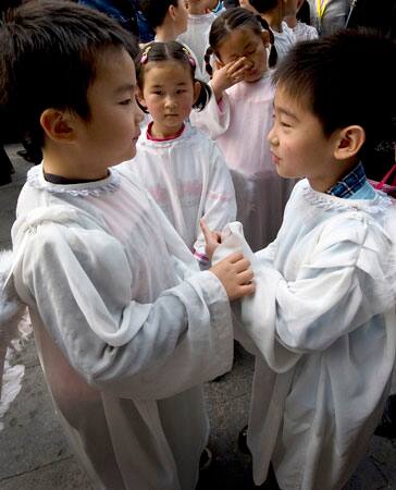 Children dressed like angels wait for a service during an Easter mass at the Nantang church in Beijing, China, Sunday, April 12, 2009.