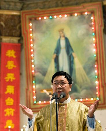 Father Han Wensheng sings and prays during an Easter mass at the Nantang church in Beijing, China, Sunday, April 12, 2009.