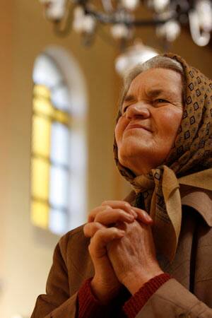 A Bosnian Catholic woman says her prayer during morning Easter prayer at the church in Vares, 40 kms north of Sarajevo, on Sunday, April 12, 2009.