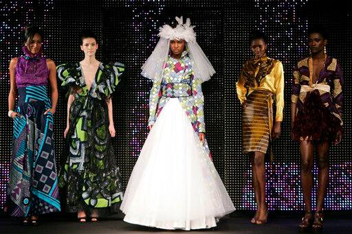 Models present creations by Cameroon-based fashion designer June during the presentation of Dutch company Vlisco`s Urban Beat Collection, in Paris. June sent out looks that combined wax print cotton with sumptuous silk or tulle, paired razor-cut skirt suits with woven straw belts and topped off outfits