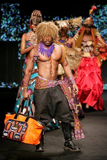 Models, including Cameroon-based fashion designer, foreground, present creations by Haif during the presentation of Dutch company Vlisco`s Urban Beat Collection, in Paris. Anggy Haif sent out looks that combined wax print cotton with sumptuous silk or tulle, paired razor-cut skirt suits