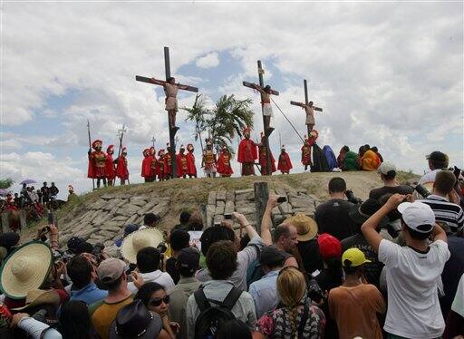 An actor dressing as Jesus Christ is yelled at by a Roman centurion as he carries a cross through the streets of Sydney, Australia, during a Good Friday