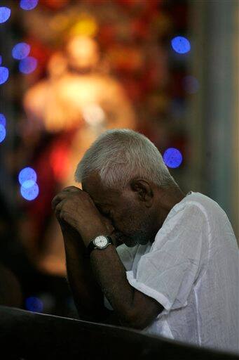 A Christian devotee prays inside a Church on the occasion of Good Friday