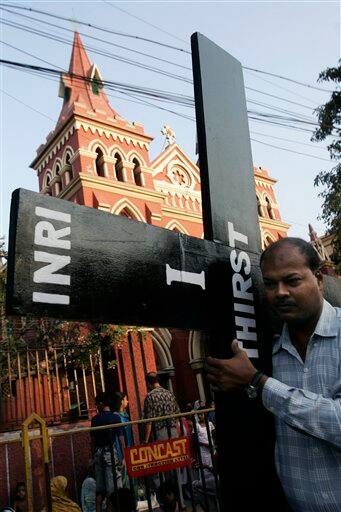 A Christian devotee carries a wooden cross as he participates in a Good Friday procession in Calcutta