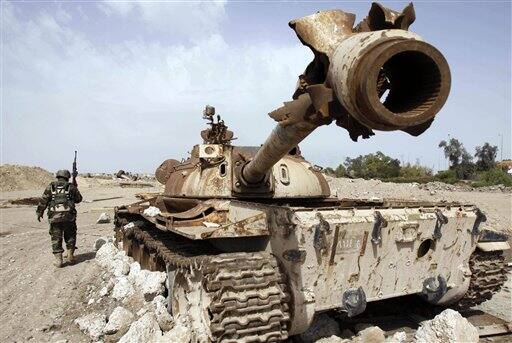 An Iraqi soldier is seen near an Iraqi Army tank, which was destroyed in the U.S.-led invasion, in Basra, Iraq`s second-largest city, 550 kilometers (340 miles) southeast of Baghdad