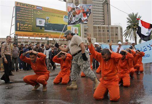 Protesters symbolically re-enact the mistreatment of detainees at the U.S.-run prison at Abu Ghraib, an incident that sparked worldwide outrage, during a rally marking the sixth anniversary of the fall of the Iraqi capital to American troops in Baghdad.