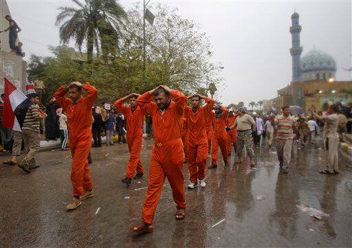 Protesters re-enact the mistreatment of detainees at the U.S.-run prison at Abu Ghraib, an incident that sparked worldwide outrage, during a rally marking the sixth anniversary of the fall of the Iraqi capital to American troops in Baghdad, Iraq