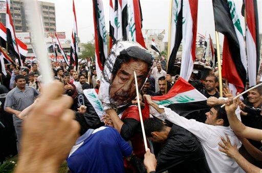 Supporters of anti-U.S. Shiite cleric Muqtada al-Sadr destroy a likeness of Iraq`s former leader, Saddam Hussein, in central Baghdad