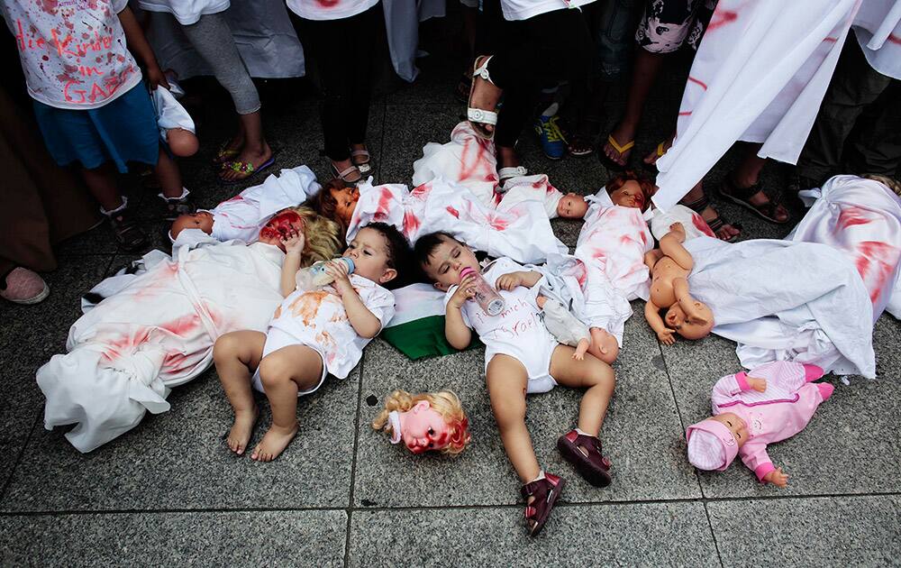 Two babies areplaced between dolls covered with red paint during a demonstration, most of them women and children, against Israel`s military offensive in Gaza, in Berlin, Germany.