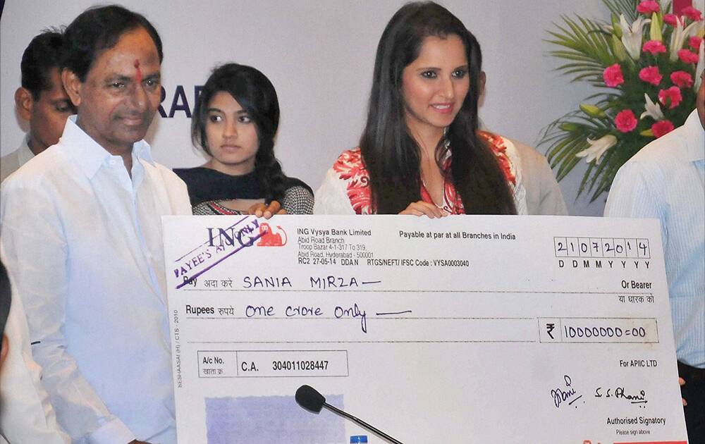 Telangana chief minister Mr K.Chandrashekhar Rao presenting a cheque Rs.1 crore to Sania Mirza at ITC Kakatiya in Hyderabad.