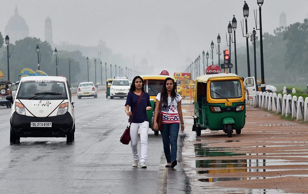 Girls enjoying a dip in temperature at the Rajpath after rains lashed in New Delhi.