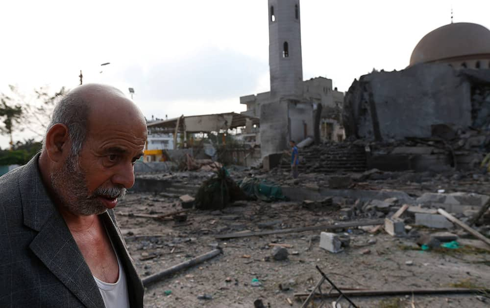 Palestinian Khaled Sharmi, 67, walks past the Al Aqsa Martyrs mosque, destroyed by an overnight Israeli strike, in Gaza City. Israel bombed five mosques, a sports stadium and the home of the late Hamas military chief across the Gaza Strip early on Tuesday, a Gaza police official said, as the UN chief Ban Ki-moon and the US Secretary of State John Kerry launched a high-level effort to end two weeks of deadly fighting. 