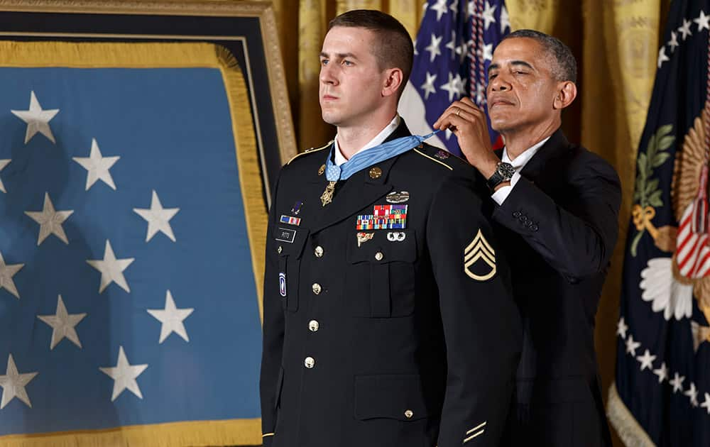 President Barack Obama bestows the Medal of Honor, the nation`s highest decoration for battlefield valor, to Ryan M. Pitts, 28, of Nashua, NH, a former Army staff sergeant who fought off enemy fighters during one of the bloodiest battles of the Afghanistan war despite his own critical injuries, in the East Room of the White House in Washington.