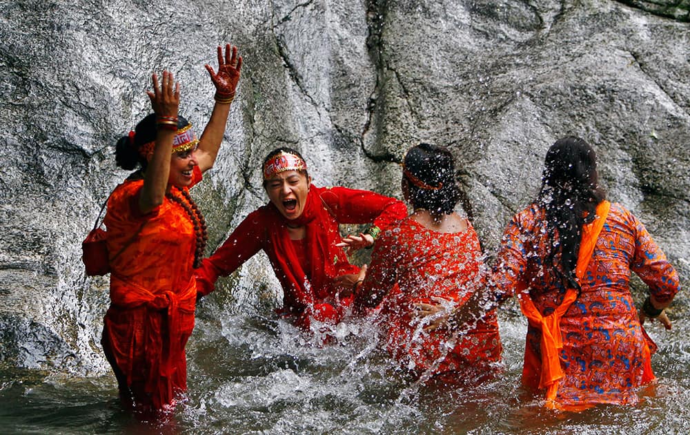 Nepalese Hindu devotees play before collecting water from the Bagmati river during the `Bol Bom` pilgrimage at Sudarijaal on the outskirts of Katmandu, Nepal.