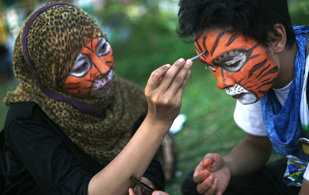 Students paint their faces during a rally calling for Sumatran tiger conservation ahead of the Global Tiger Day in Medan, North Sumatra, Indonesia.