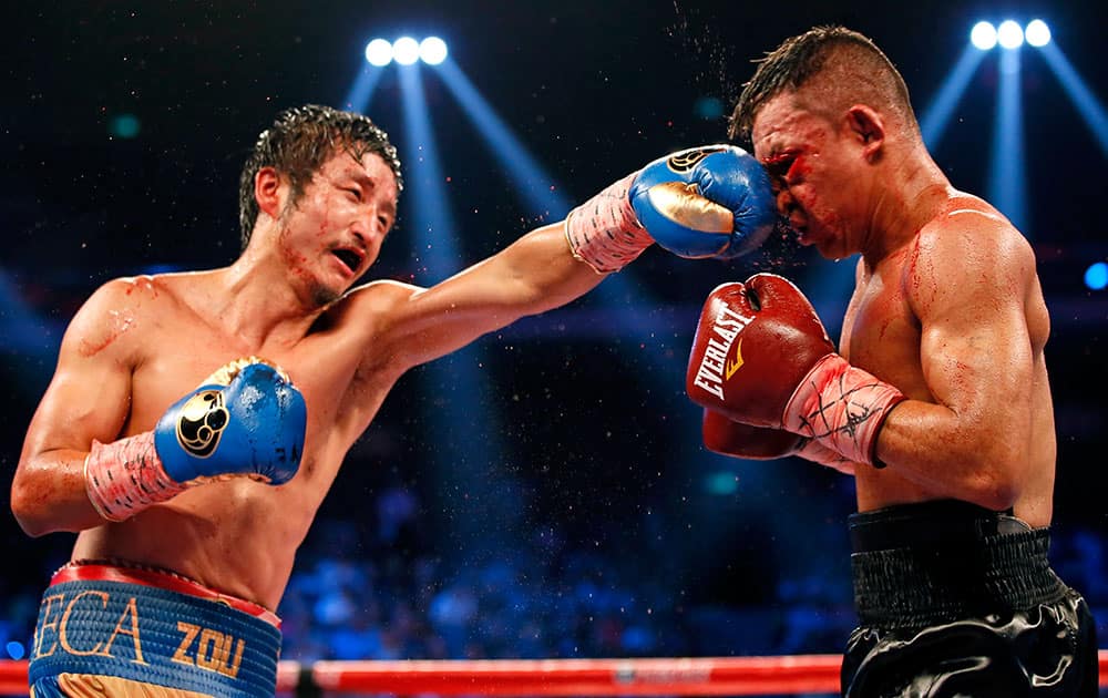 Chinese boxer Zou Shiming, left, delivers a punch to Colombian boxer Luis De La Rosa during the WBO international flyweight title match in Macau, China.