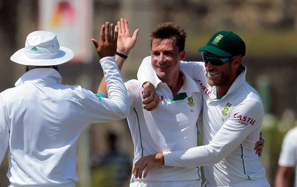 South African bowler Dale Steyn, center, celebrates taking the wicket of Sri Lankan batsman Kaushal Silva with team mates Hashim Amla, left, and Faf du Plessis during the fifth day of the first test cricket match between Sri Lanka and South Africa in Galle, Sri Lanka.