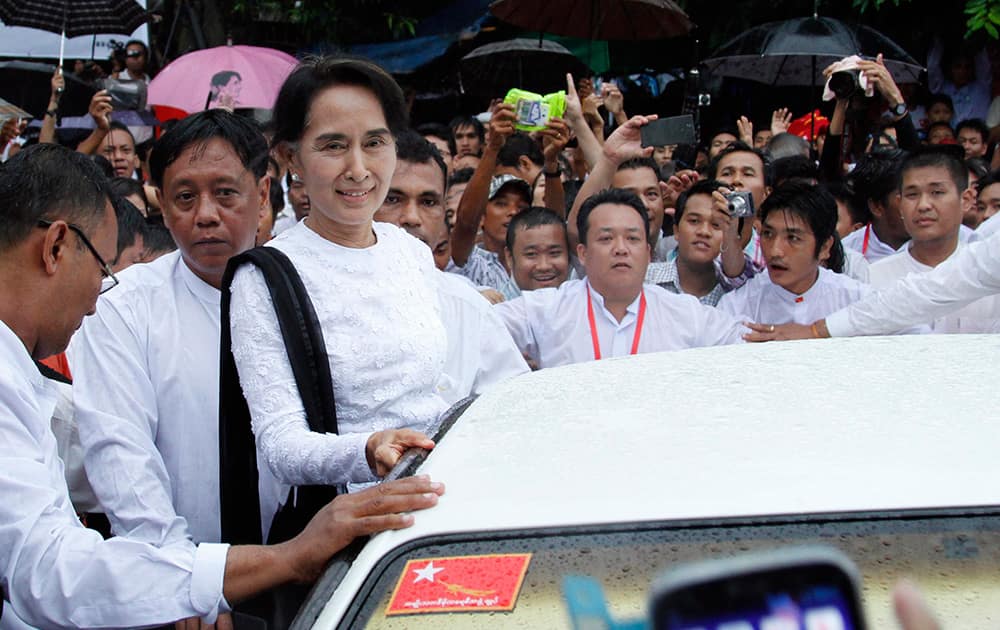 Myanmar opposition leader Aung San Suu Kyi, third from left in front, greets supporters from vehicle after she attended the 67th anniversary of Martyrs` Day at the headquarters of her National League for Democracy party in Yangon, Myanmar .