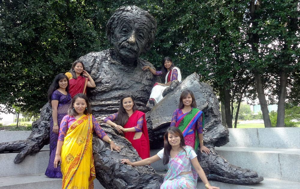 A group of seven women mountaineers from Nepal posing for a group picture at the statue of Albert Einstein outside the Foggy Bottom headquarters of the State Department in Washington.