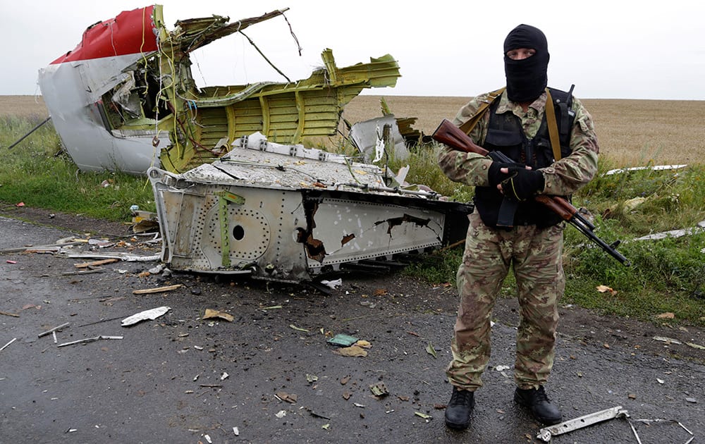 A Pro-Russian fighter stands guard at the site of a crashed Malaysia Airlines passenger plane near the village of Hrabove, Ukraine, eastern Ukraine.